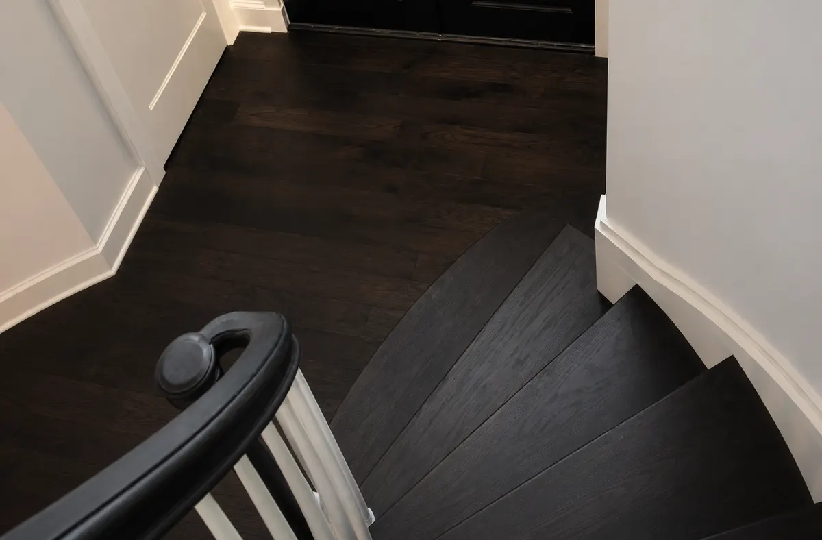 A finished wide-plank floor laid in a herringbone field, the work the 2017 award recognised